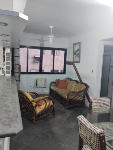 a living room with two chairs and a bed at Apto Enseada Guarujá in Guarujá