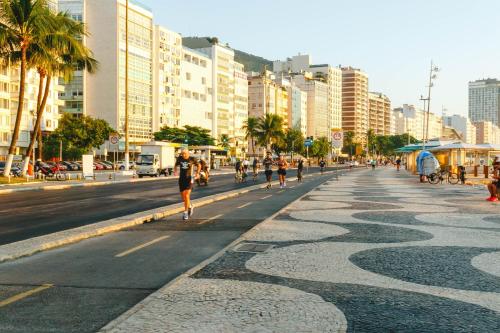 una strada cittadina con gente che va in bicicletta per strada di Palace Beach Hostel a Rio de Janeiro