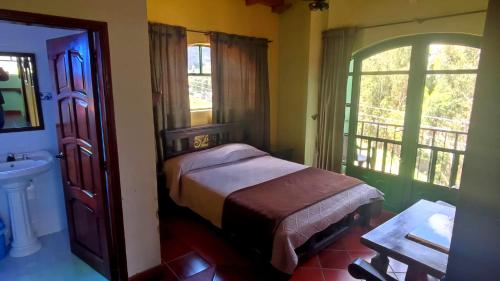 una camera con letto, lavandino e finestra di Hospedaje Mirador de Pueblo viejo a Guatavita