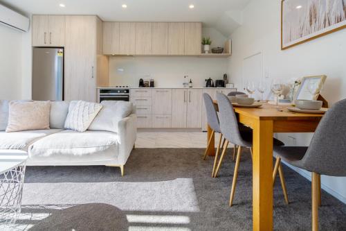 a living room with a table and a white couch at Stadium Suite - CBD in Christchurch