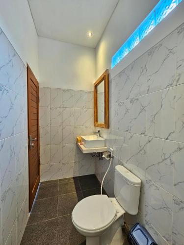 a bathroom with a toilet and a sink at Dewi Putri House in Ubud