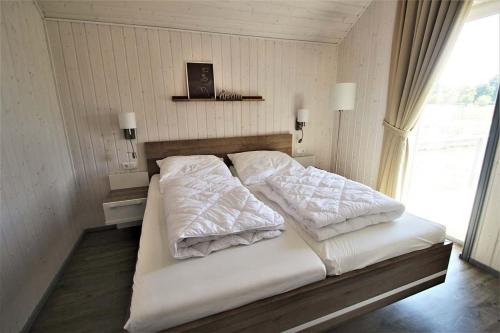 ein Bett mit zwei Kissen darauf in einem Schlafzimmer in der Unterkunft Seeschwalbe Classic 309 in Mirow