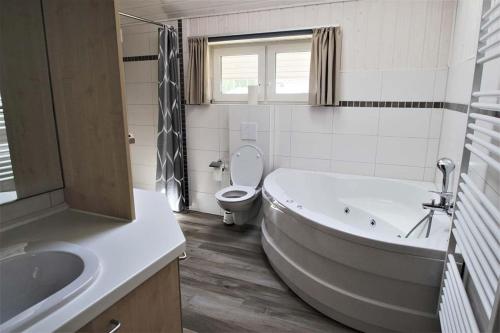 ein Badezimmer mit Badewanne, Toilette und Waschbecken in der Unterkunft Seeschwalbe Classic 309 in Mirow