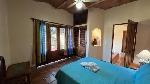 a bedroom with a blue bed in a room with windows at Villas Chulavista in Sayulita