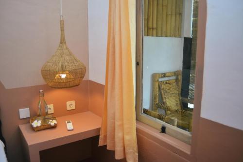 baño con lavabo y ventana con lámpara. en Mango Tree House, en Gili Trawangan