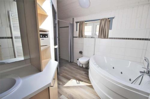a bathroom with a tub and a sink and a toilet at Seeschwalbe Classic 322 in Mirow