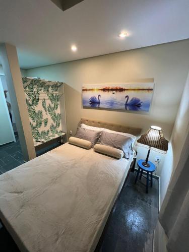 テオフィロ・オトニにあるPousada Cristais SUITE 15のベッドルーム1室(大型ベッド1台、テーブル上のランプ付)