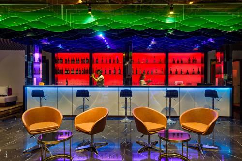a bar with chairs and a display of wine bottles at Satya Da Nang Hotel Han Market in Da Nang