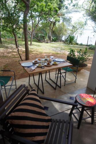 a wooden table and chairs on a patio at Lagoon House Rekawa in Tangalle