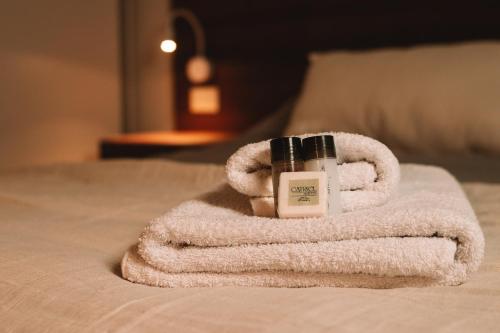 a pile of towels and a bottle of lotion on a bed at Catriel Suites in Catriel