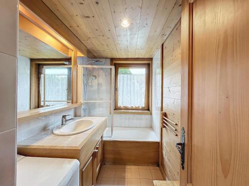 uma casa de banho com um lavatório e uma banheira em Appartement Combloux, 3 pièces, 6 personnes - FR-1-560-140 em Combloux