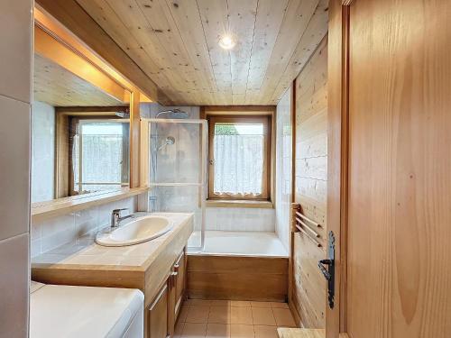 une salle de bain avec un lavabo et une baignoire dans l'établissement Charmant appart 3 pièces proche des pistes avec parking et terrasse - FR-1-560-140, à Combloux