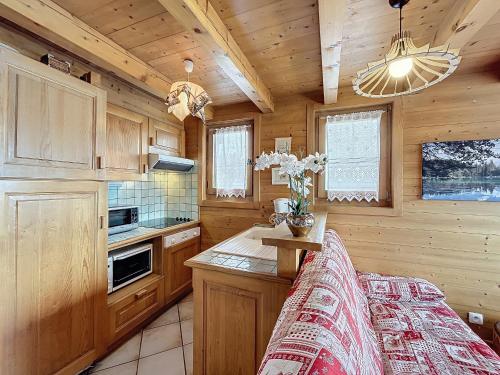 - une cuisine avec des placards en bois et une table dans une cabine dans l'établissement Charmant appart 3 pièces proche des pistes avec parking et terrasse - FR-1-560-140, à Combloux