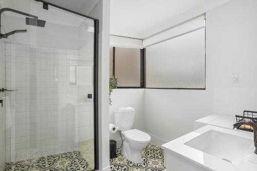 a white bathroom with a toilet and a shower at Stylish Riverside 1Bed/Studio with Rooftop Pool in Brisbane