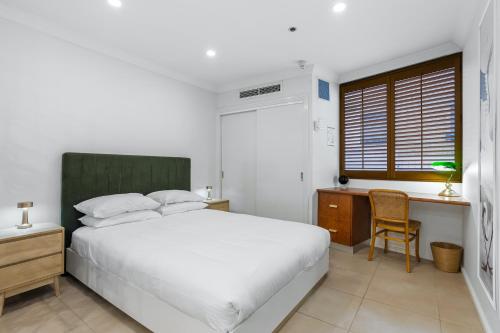 a bedroom with a bed and a desk and a chair at Stylish Riverside 1Bed/Studio with Rooftop Pool in Brisbane