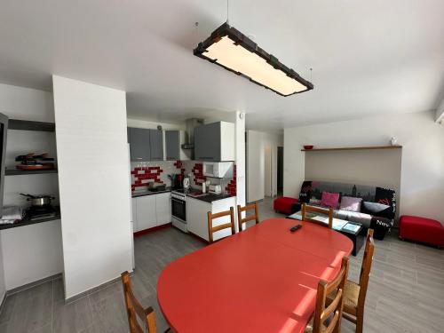 un salon avec une table rouge et une cuisine dans l'établissement Charmant T2 rénové proche centre de Villard de Lans et station - FR-1-515-210, à Villard-de-Lans