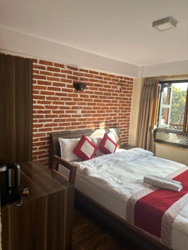 a bedroom with a bed and a brick wall at Hotel vintage Home in Bhaktapur