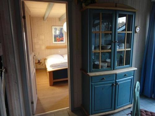 um armário azul numa sala com um quarto em Wildgans 114 em Mirow