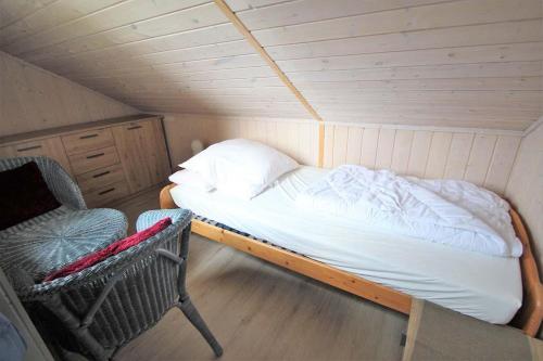 a small room with a bed and a chair in it at Wildgans 128 in Mirow