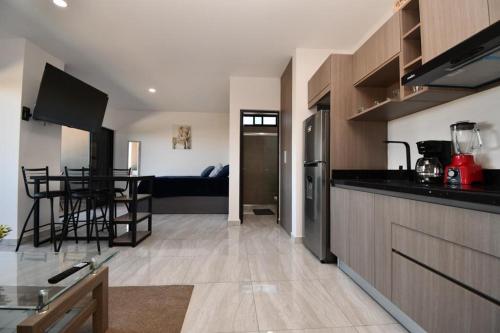 eine Küche und ein Wohnzimmer mit einem Tisch in der Unterkunft Loft de lujo con 9 albercas y vistas al campo de golf in Mazatlán