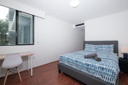 a bedroom with a bed and a desk and a window at Fantastic 3 Bds apartment Darling Harbour & Fish Market & Chinatown & Casino & Central in Sydney