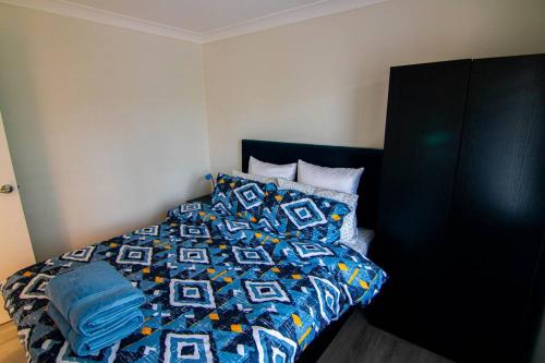 a bed with a blue comforter in a bedroom at Big quiet enclave amazing views in Wentworth Falls