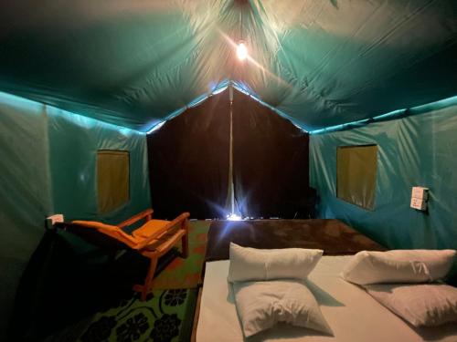 Cette chambre comprend une tente verte avec deux oreillers. dans l'établissement Peacock Hill Glamp, à Gampola