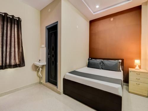 um quarto com uma cama e uma cabeceira em madeira em OYO HOTEL ORR RESIDENCY em Hyderabad