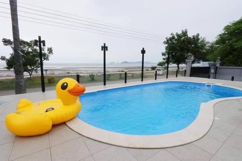 un canard en caoutchouc jaune assis à côté d'une piscine dans l'établissement Visas Seaview villa บ้านวิเศษ Pranburi, à Ban Pru Yai