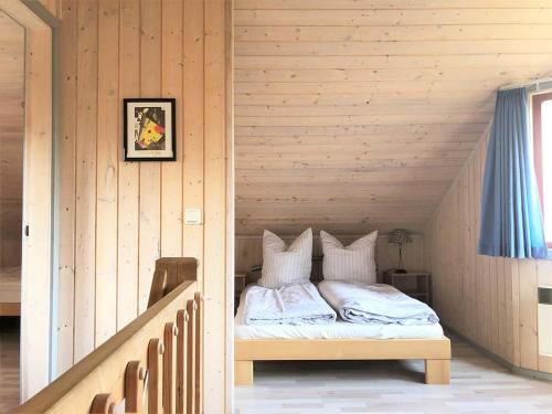 a bedroom with a bed in a wooden room at Wildgans 41 in Mirow