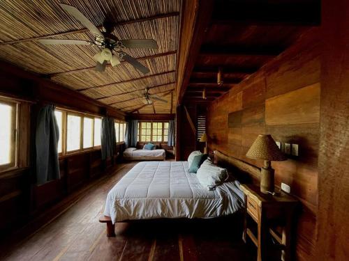 a bedroom with a bed and a ceiling fan at La Hacienda de Las Planadas - next YankeeBeach in Escamequita