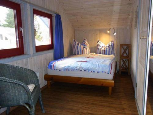 a small bedroom with a bed in a wooden cabin at Wildgans 42 in Mirow