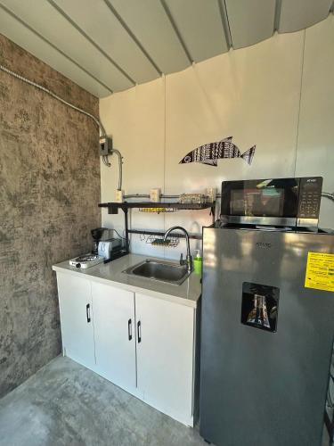 a kitchen with a sink and a refrigerator at Apple House cerca de la playa in Barra de Navidad