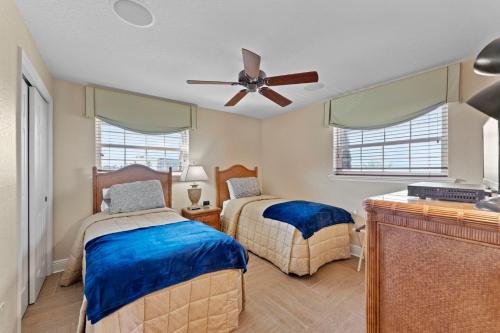 um quarto com 2 camas e uma ventoinha de tecto em Ola Grande 218 em Cocoa Beach