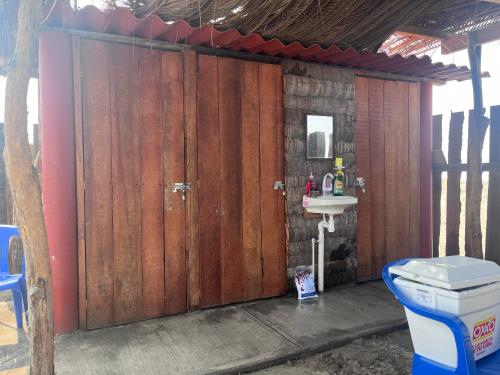 a bathroom with a wooden door and a sink at ZONA DE CAMPING ANGEL DE EL MAR in Playa Azul