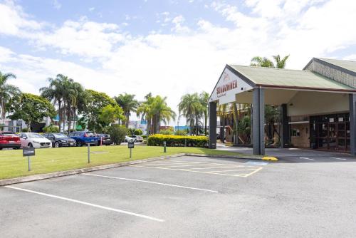 a parking lot in front of a car dealership at Sundowner Hotel Motel in Caboolture