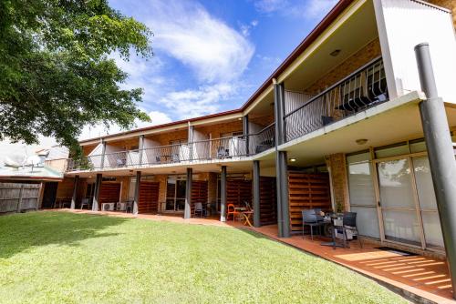 an exterior view of a building with a yard at Sundowner Hotel Motel in Caboolture