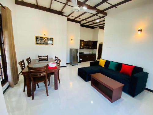 ein Wohnzimmer mit einem Sofa und einem Tisch in der Unterkunft Tango Sunrise Villa in Tangalle