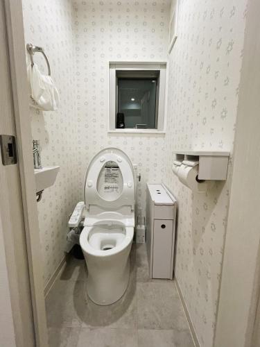 a small bathroom with a toilet and a window at miyabi I - 雅 I in Tokyo