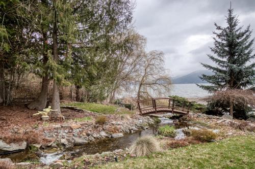 a wooden bridge over a stream with a pond sidx sidx sidx at Kootenai Haus in Sandpoint