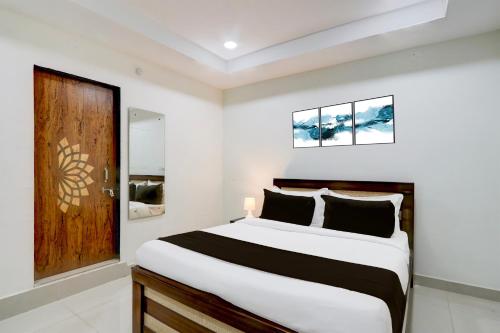 a bedroom with a bed and a wooden door at Super Collection O Madhapur near Cyber Tower in Hyderabad