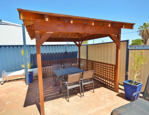 a wooden pergola with a table and chairs on a patio at Blue Ocean Villa 2 - Kalbarri WA in Kalbarri