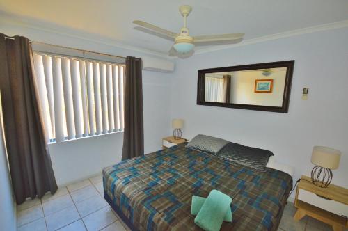 a bedroom with a bed and a mirror on the wall at Blue Ocean Villa 2 - Kalbarri WA in Kalbarri
