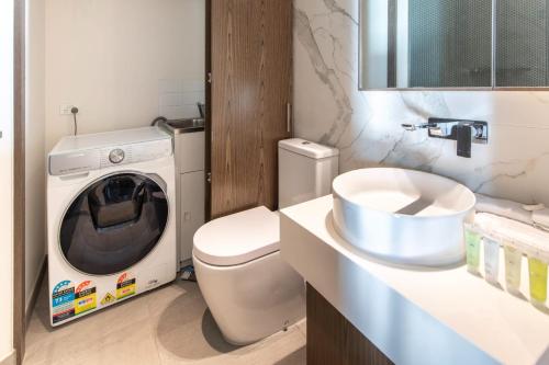 uma casa de banho com uma máquina de lavar roupa e uma máquina de lavar roupa. em Fit For A Queen with Free Parking-Pool-Gym em Melbourne