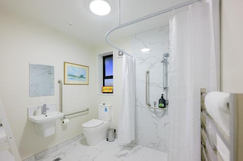 een witte badkamer met een douche en een toilet bij Stargazing family apartment C in Lake Tekapo