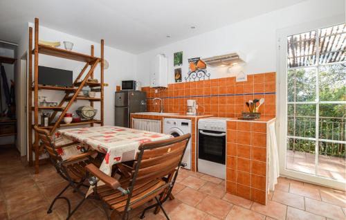 - une cuisine avec une table, une cuisinière et un évier dans l'établissement Cozy Home In Piscia Rossa With Wifi, à Afa