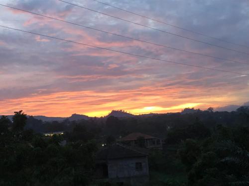 a view of a sunset with mountains in the background at Casa de Ferias in São Tomé