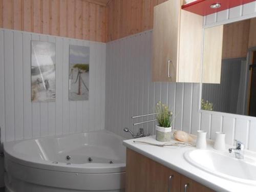 a bathroom with a tub and a sink at Haubentaucher 80 in Rechlin