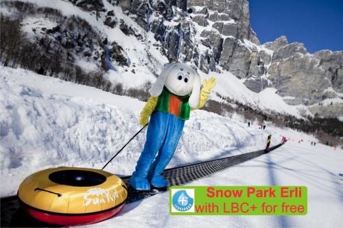 a stuffed animal is standing in the snow next to a snow tank at Hotel Paradis-Leukerbad-Therme in Leukerbad