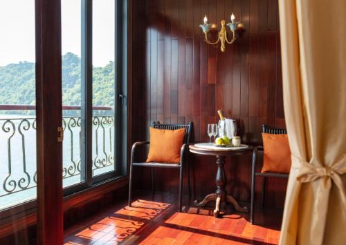a room with a table and chairs and a window at Indochine Cruise Lan Ha Bay in Ha Long